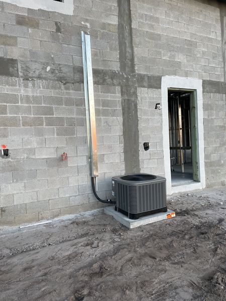 New AC condenser installed on a concrete pad